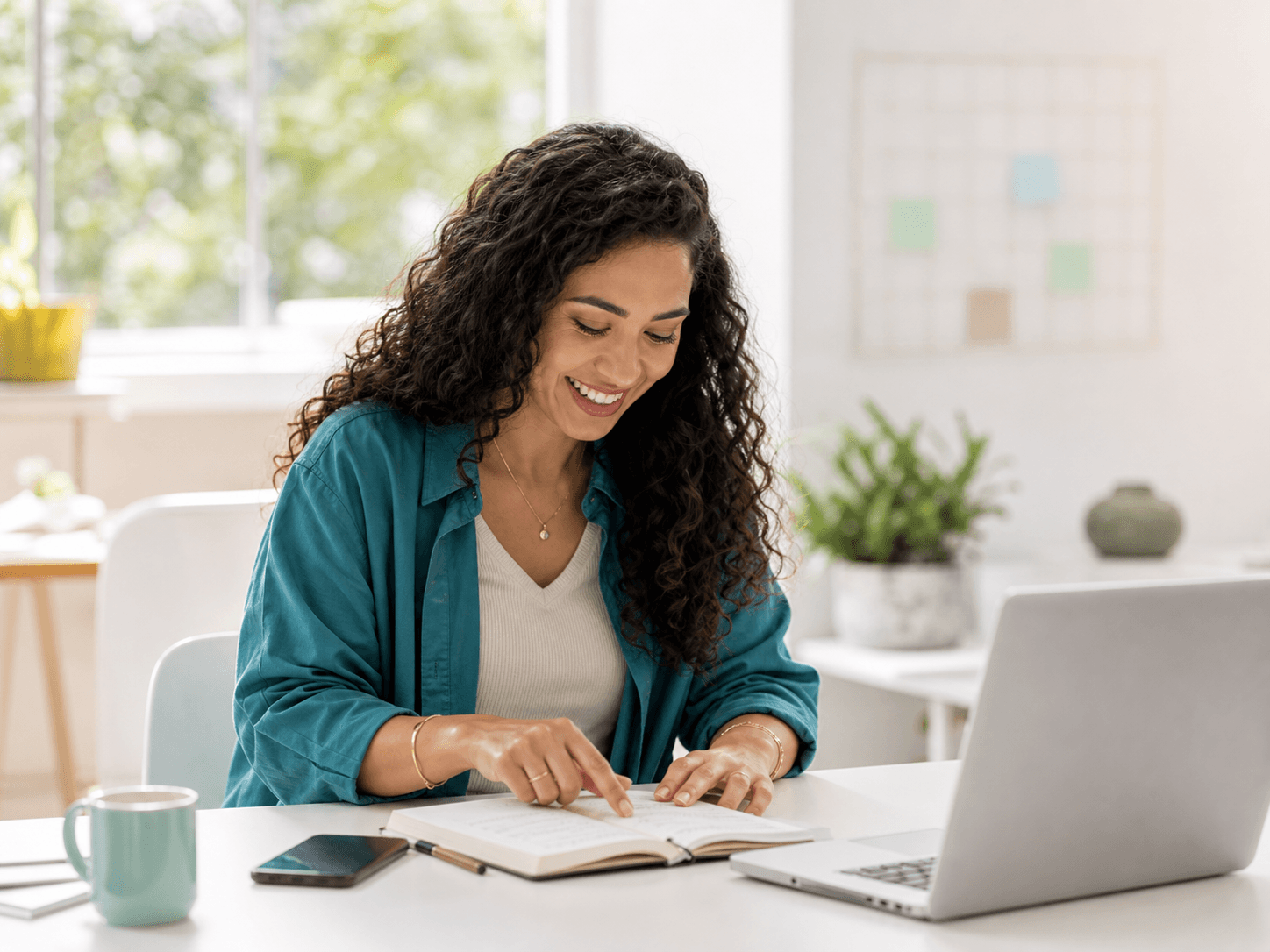 A consultant reviewing handwritten work notes beside her laptop